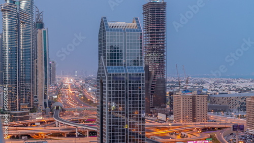 Dubai city skyline panoramic view with metro and cars moving on city's busiest highway aerial night to day