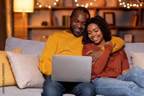 Wallpaper Mural Happy african american spouses sitting on couch, using computer Torontodigital.ca