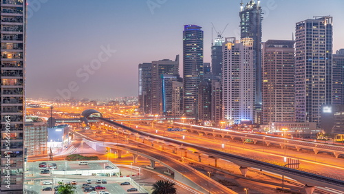 Dubai Marina skyscrapers and Sheikh Zayed road with metro railway aerial day to night , United Arab Emirates