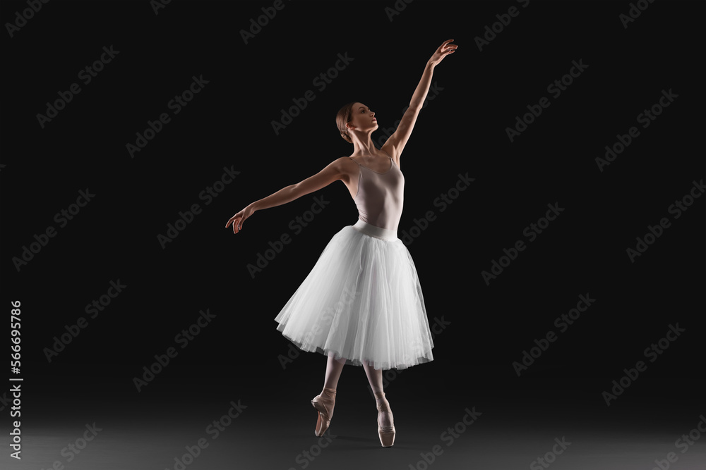 Young ballerina practicing dance moves on black background Young ballerina practicing dance moves on black background