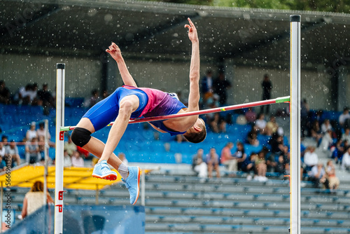 male athlete high jump in rain