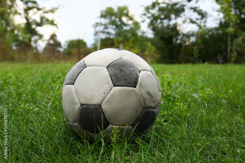 Dirty soccer ball on fresh green grass outdoors © New Africa