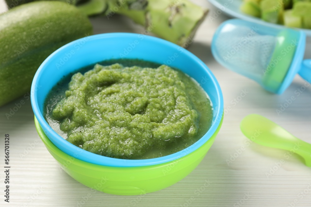 Healthy baby food. Bowl with tasty broccoli puree on white wooden table, closeup Healthy baby food. Bowl with tasty broccoli puree on white wooden table, closeup