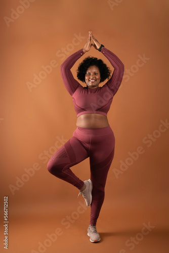 body positive curvy black girl wearing sportswear in studio doing yoga and exercising