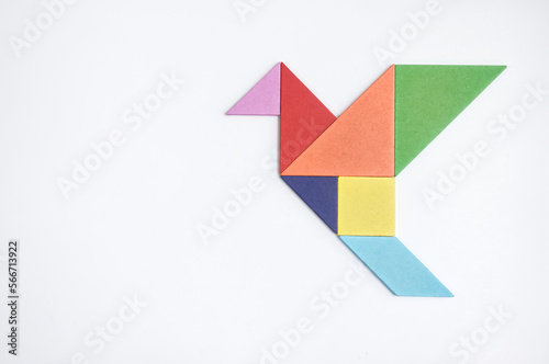 color tangram puzzle in flying bird shape on white background photo