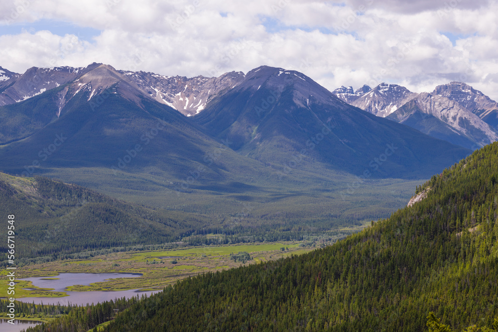Rocky mountains in summer - a wonderful day, summer, cloudy with clearings. green meadows, coniferous forest, and lakes. Rocky mountains in summer - a wonderful day, summer, cloudy with clearings. green meadows, coniferous forest, and lakes.