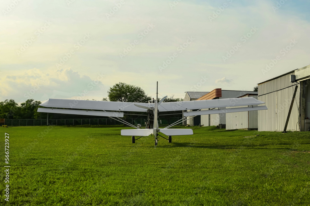 Modern white airplane on green grass outdoors