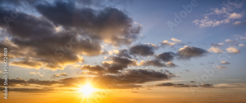 A sunset sky with orange and dark stormy clouds as a background or texture