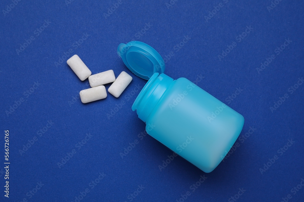 Jar with chewing gums on blue background, flat lay Jar with chewing gums on blue background, flat lay