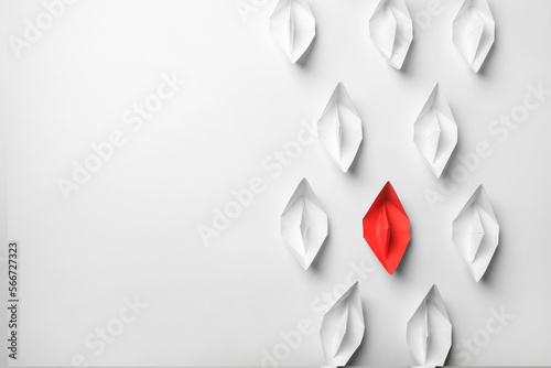Red paper boat among others on white background, flat lay with space for text. Uniqueness concept