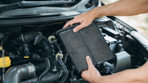 Young man checking and maintenance air filter on his car. Car repair and maintenanc concept.