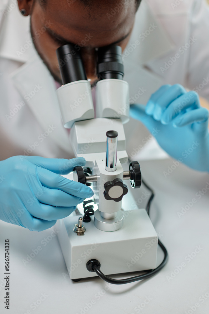 Researcher working with microscope in medical office Researcher working with microscope in medical office