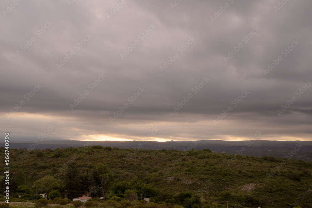 Dramatic cloudscape. Panorama view of the hills and field under a cloudy sky, at dusk. 