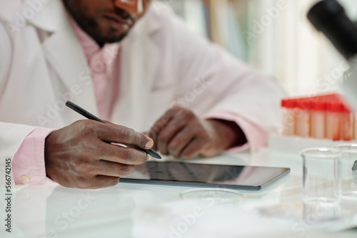 Scientist filling form on tablet computer after finishing work on big reseach photo