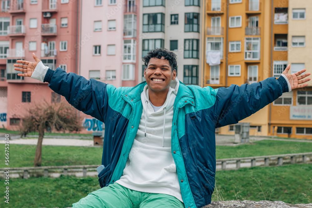 happy young man with arms raised outdoors