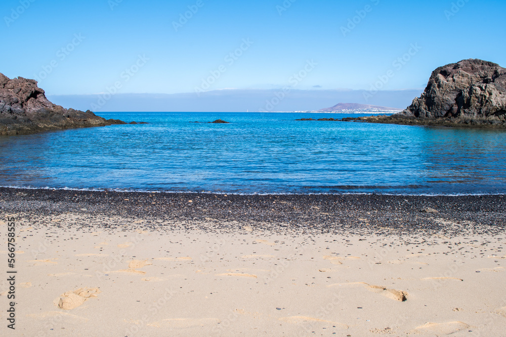 Stunning view of exotic colors on Lanzarote, Canary Islands, Spain, Europe. Turquoise color of the sea and crystalline sea. Black rocks and fine sands. Papagayo Beach (Playa de Papagayo).