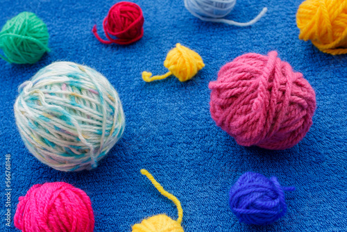 Close-up of colorful yarn balls on blue background 