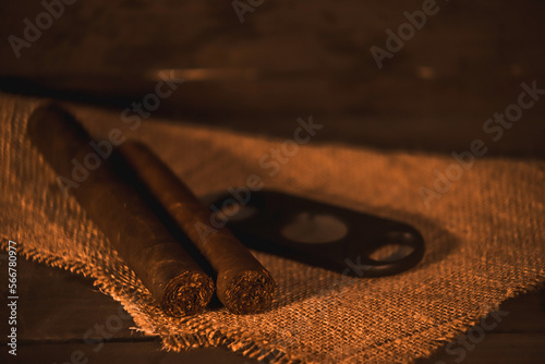 Billede på lærred Handmade Caribbean tobacco cigar, on rustic wooden table with coppery colors and