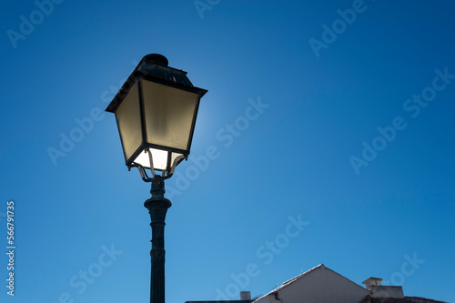 Lantern style street lamp, against a blue sky.