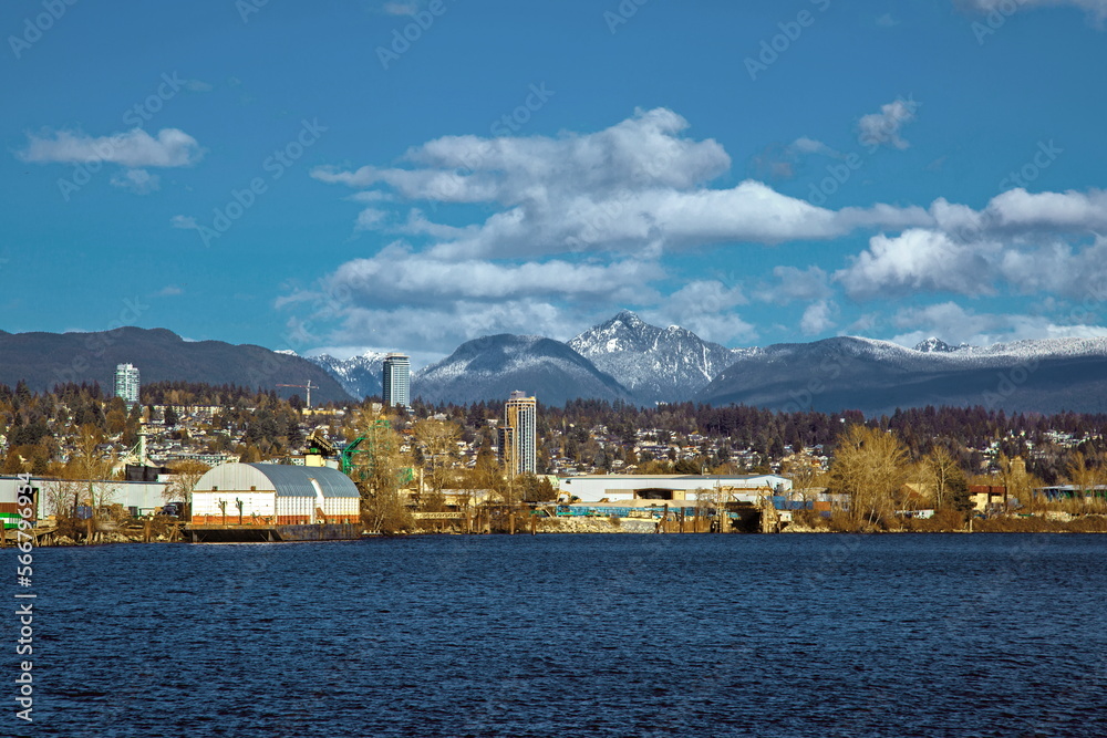 Residential and industrial area on the banks of the Fraser  against the backdrop of a snowy mountain range