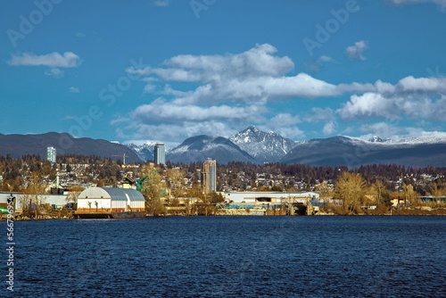 Residential and industrial area on the banks of the Fraser  against the backdrop of a snowy mountain range © Alex Lyubar