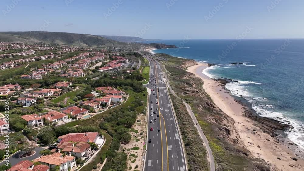 Drone shot of the Pacific Coast Highway or PCH California with views of the ocean, beach, freeway and luxury residential neighborhood homes on a sunny day. Drone shot of the Pacific Coast Highway or PCH California with views of the ocean, beach, freeway and luxury residential neighborhood homes on a sunny day.