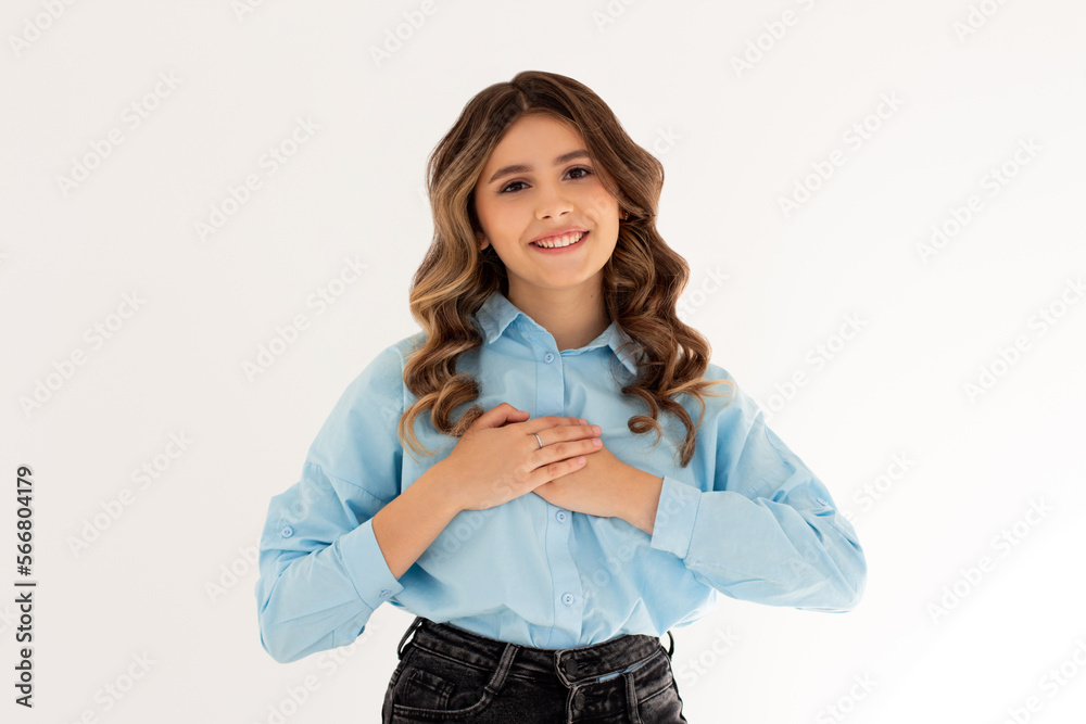 Close up of happy smiling woman say thank you, holding hands on heart grateful, express gratitude, standing against white background. Close up of happy smiling woman say thank you, holding hands on heart grateful, express gratitude, standing against white background.