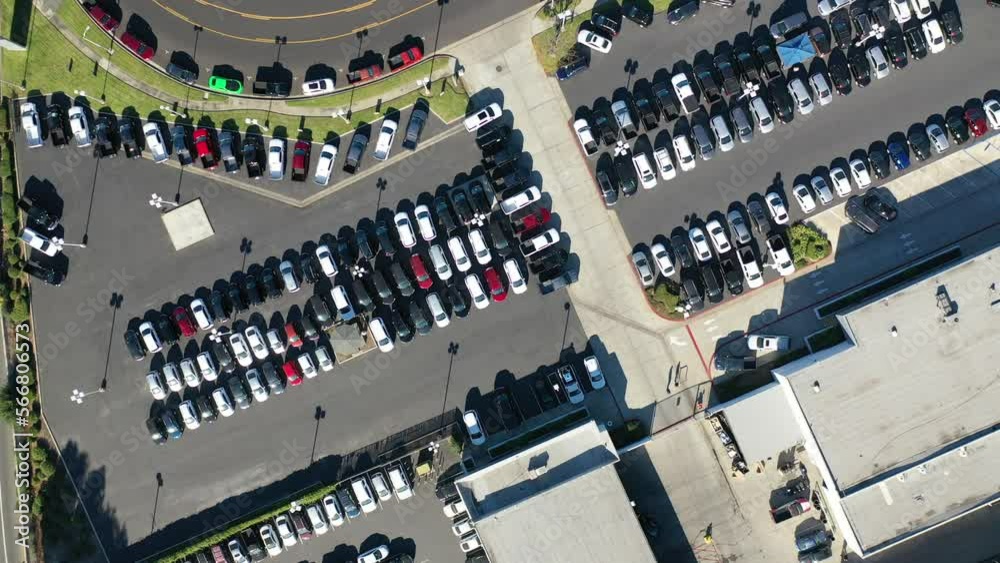 Aerial drone shot of cars on auto dealer or dealership lot.