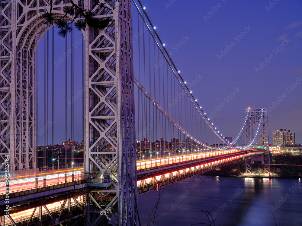 Light Trails from streaming rush hour traffic across the George Washington Bridge connecting North New Jersey to upper Manhattan at dusk