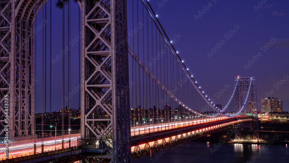 Light Trails from streaming rush hour traffic across the George Washington Bridge connecting North New Jersey to upper Manhattan at dusk