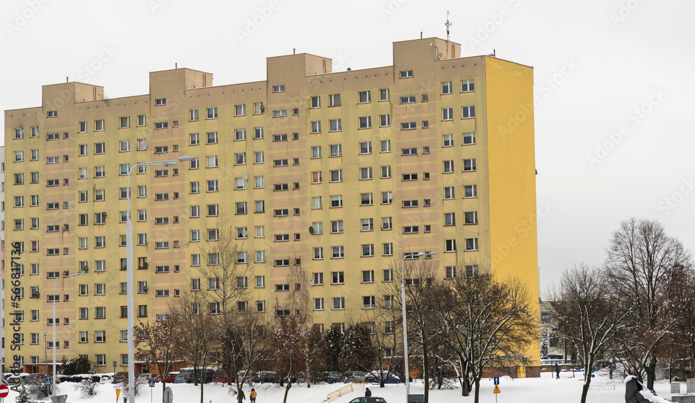 Dziesięciopiętrowy, żółty , blok mieszkalny  w mieście zimą .  - obrazy, fototapety, plakaty 