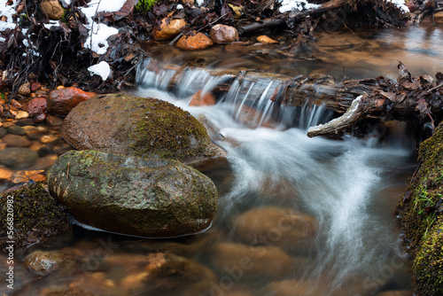 Small Forest Stream With Waterfalls in Winter With Icicles