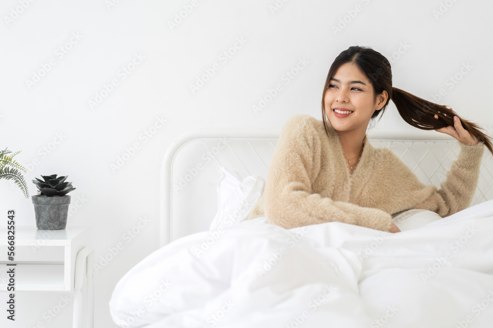 Portrait of smiling cheerful beautiful pretty asian woman clean fresh healthy white skin posing smile in pajamas white clothes.Girl felling relax and enjoy time on the bed at home.asia beauty Portrait of smiling cheerful beautiful pretty asian woman clean fresh healthy white skin posing smile in pajamas white clothes.Girl felling relax and enjoy time on the bed at home.asia beauty