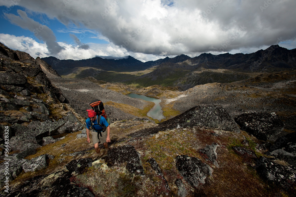 One man backpacking / hiking over a backcountry pass with fall colors. One man backpacking / hiking over a backcountry pass with fall colors.