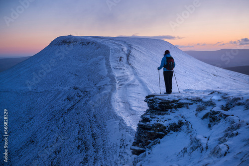 Female hiker looks towards Pen Y Fan at dawn from Corn Du, Brecon Beacons national park, Wales photo