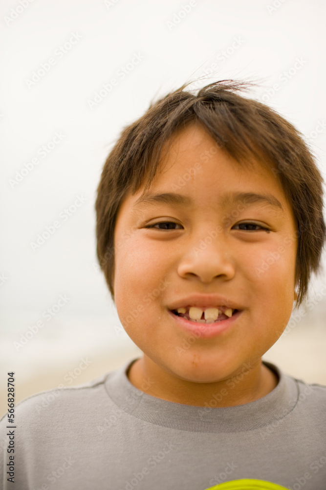 A young boy with missing teeth smiles for the camera while enjoying a clear day on a beach in La Jolla Cove, San Diego, Callifornia. A young boy with missing teeth smiles for the camera while enjoying a clear day on a beach in La Jolla Cove, San Diego, Callifornia.