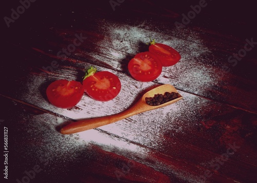 Red Tomatoes alongside peppers on wooden board