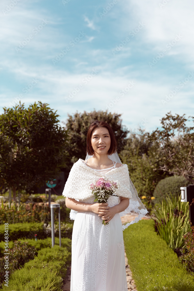 Vertical portrait of happy asian bride holding bouquet smiling at outdoor wedding, copy space Vertical portrait of happy asian bride holding bouquet smiling at outdoor wedding, copy space