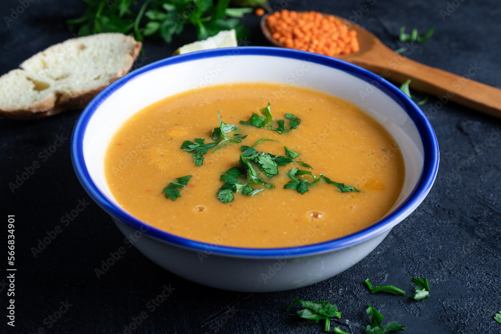Red lentil soup puree in a bowl on dark background. Traditional middle eastern cuisine. Vegan food. Red lentil soup puree in a bowl on dark background. Traditional middle eastern cuisine. Vegan food.