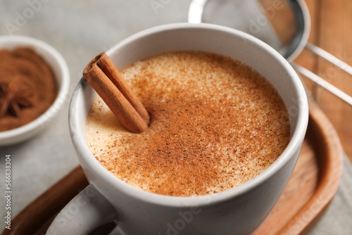 Delicious eggnog with anise and cinnamon on wooden table, closeup