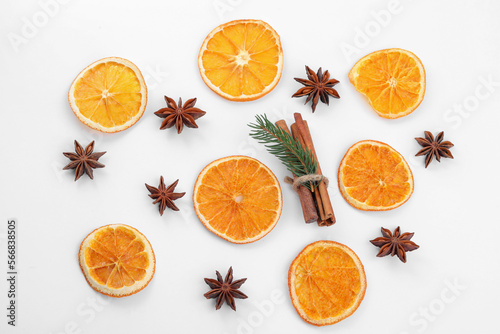 Flat lay composition with dry orange slices, anise stars and cinnamon sticks on white background