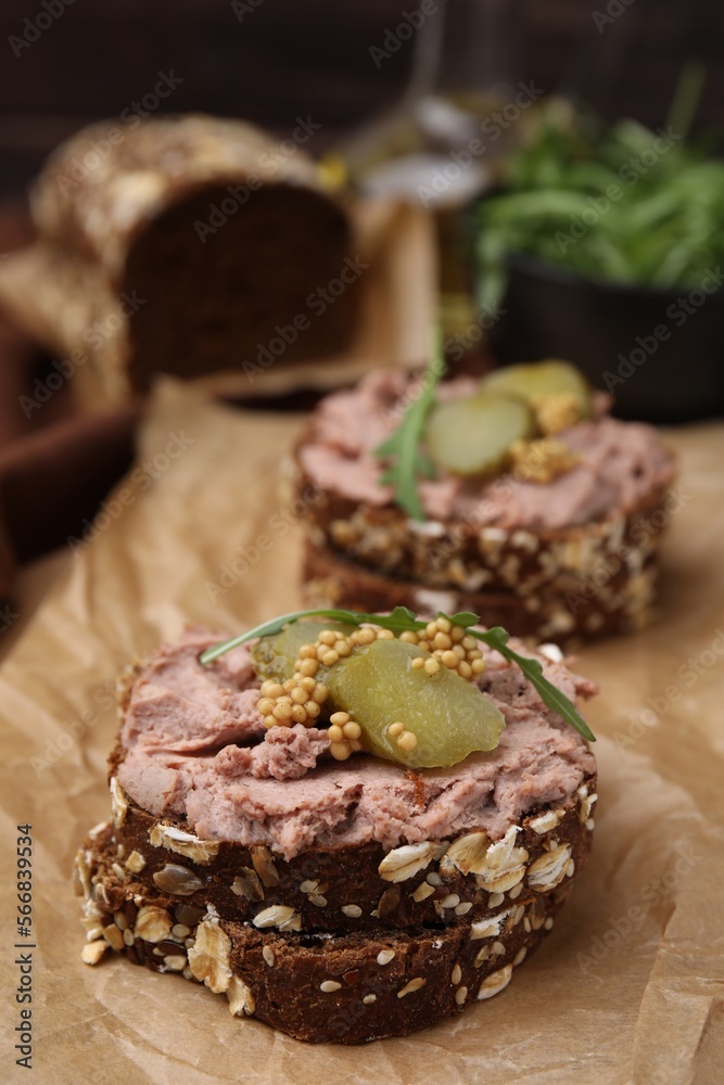 Delicious liverwurst sandwiches with pickled cucumber and mustard on table, closeup