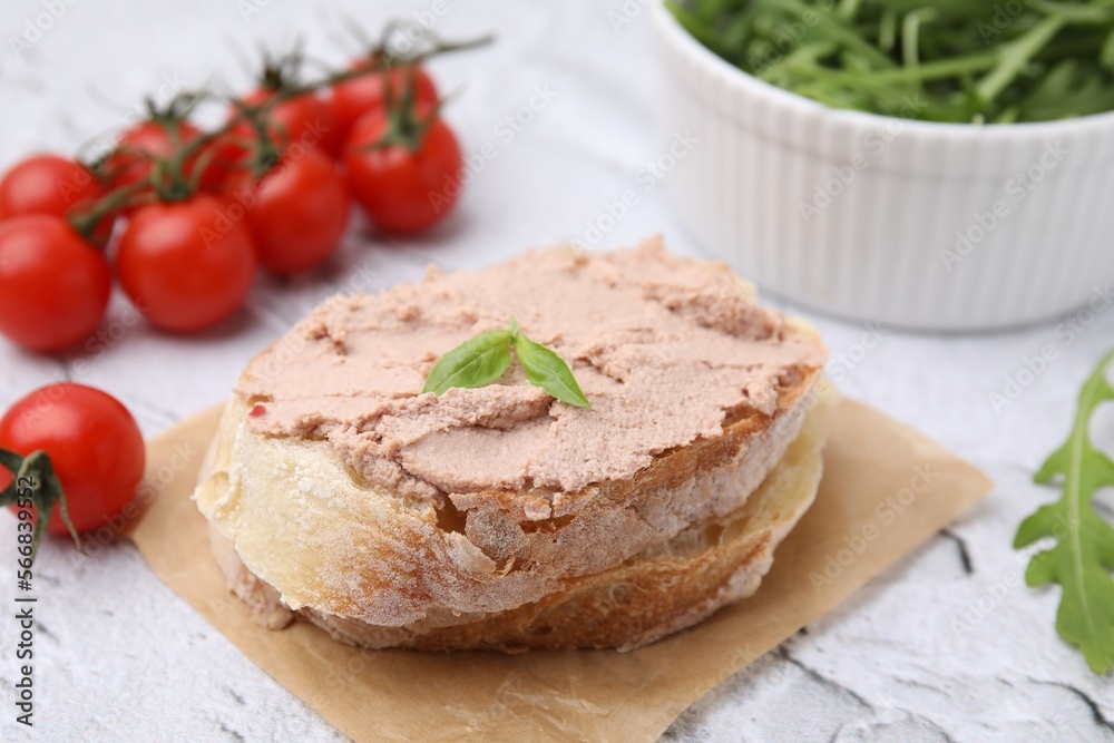 Delicious liverwurst sandwich with basil on white textured table, closeup