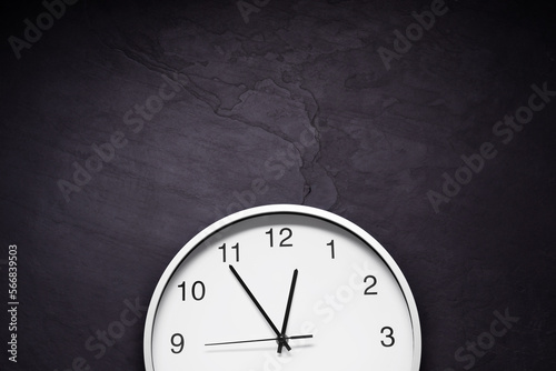 Stylish round clock on black table, top view with space for text. Interior element