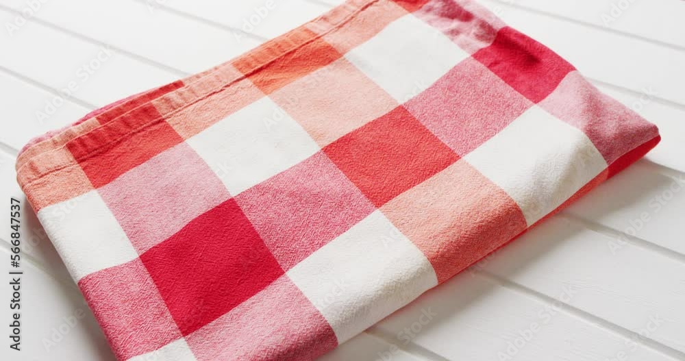 Close up of folded red and white checkered blanket on white background with copy space Close up of folded red and white checkered blanket on white background with copy space
