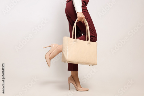 Young woman with stylish bag on white background, closeup