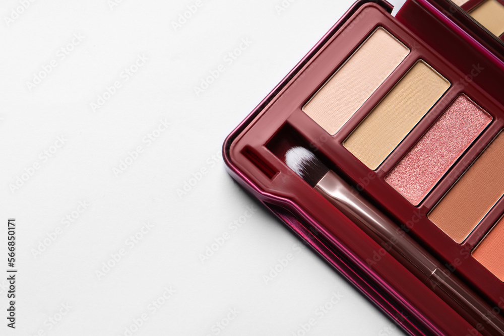 Beautiful eye shadow palette and brush on white table, top view. Space for text Beautiful eye shadow palette and brush on white table, top view. Space for text