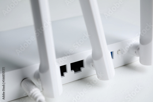 New modern Wi-Fi router on white table, closeup