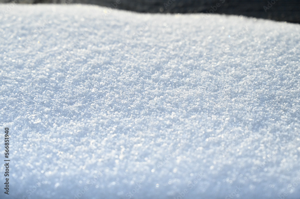 Snow surface on sunny winter day. Close up of fresh white snow texture.