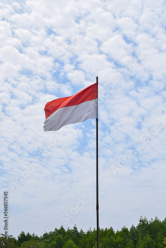 Indonesian Flag, Red and White, waving in the wind with blue sky background